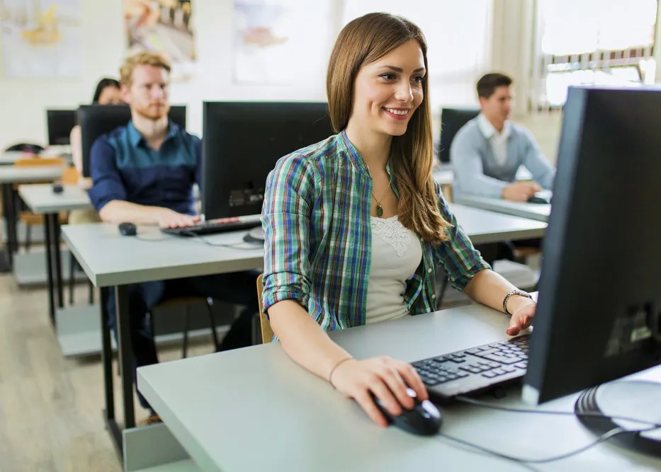 woman taking online exam in classroom or test centre